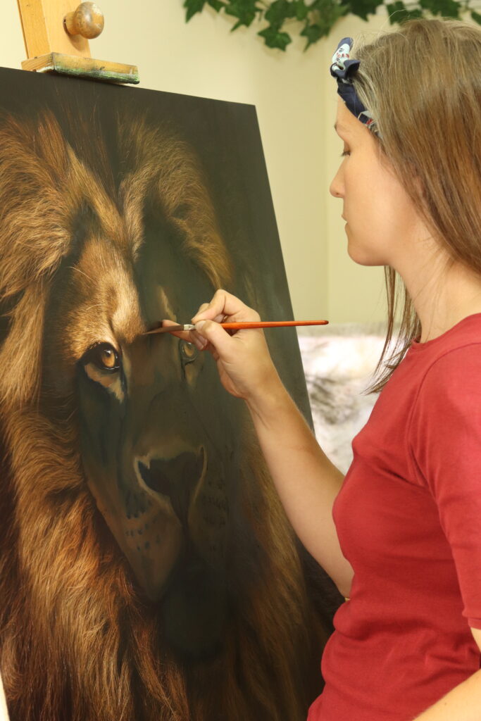 The artist at work, painting a Lion.